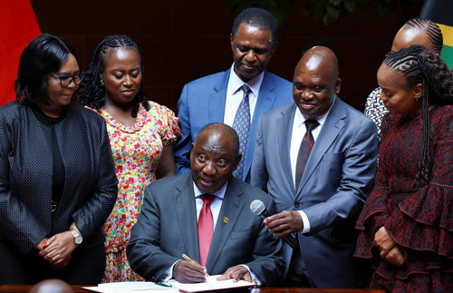 Cyril Ramaphosa and colleagues signing the NHI Bill